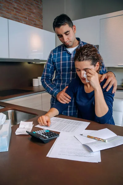 Desperate young woman with debts reviewing the bills — Stock Photo, Image
