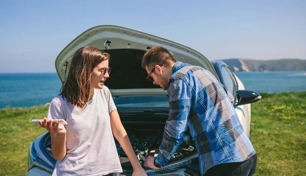 Couple argue while fix their broken down car — Stock Photo, Image