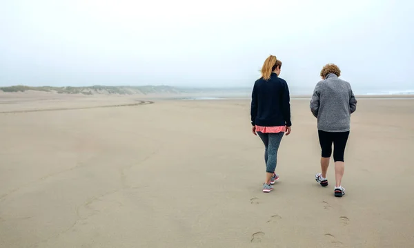 Due donne che camminano sulla spiaggia — Foto Stock