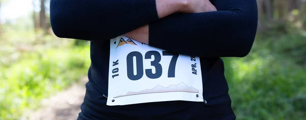 Atleta de trail femenino irreconocible posando con número de carrera — Foto de Stock