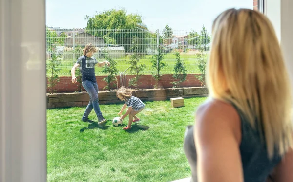 Mother watching her husband and son playing — Stock Photo, Image