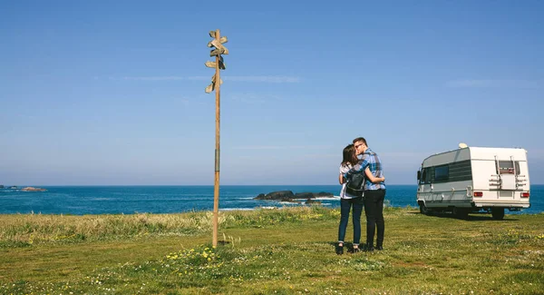 Casal beijando perto da costa com um campista — Fotografia de Stock