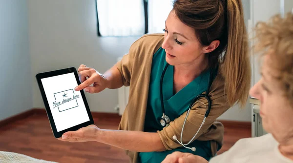 Médico mostrando tableta a paciente mayor —  Fotos de Stock