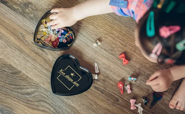 Menina bebê brincando com grampos de cabelo sentado no chão — Fotografia de Stock