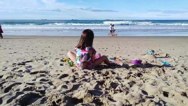 Menina irreconhecível brincando com seus brinquedos na praia — Vídeo de Stock