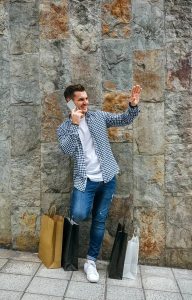 Young man with shopping bags and mobile — Stock Photo, Image