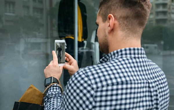 Man taking a photo of a shop window of a fashion store — Stock Photo, Image