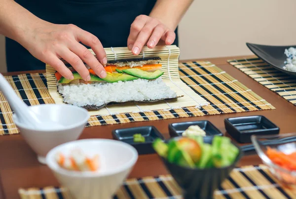 Detalle de manos de mujer chef enrollando sushi japonés —  Fotos de Stock