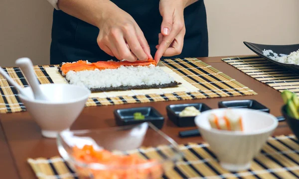 Chef-kok handen plaatsen ingrediënten op rijst — Stockfoto