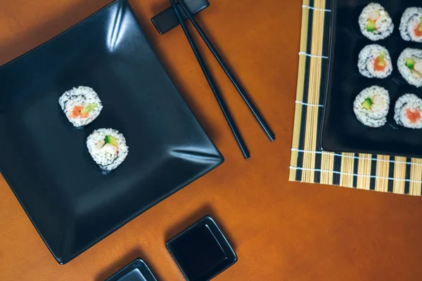 Sushi maki rullar på en tallrik och fack — Stockfoto
