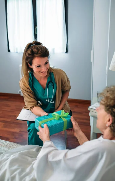 Paciente sênior dando um presente para seu médico — Fotografia de Stock