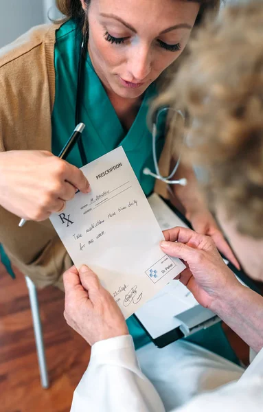 Arzt gibt älteren Patienten ein Rezept — Stockfoto