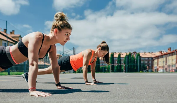 Sportswomen doing push-ups — Stock Photo, Image