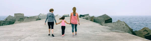 Baksidan på tre kvinnliga generationer promenader — Stockfoto