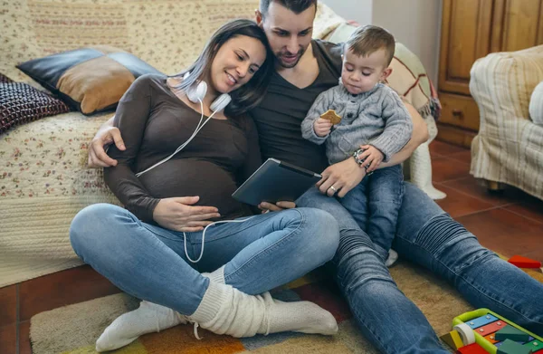 Familj med barn och gravid mor tittar tablett — Stockfoto