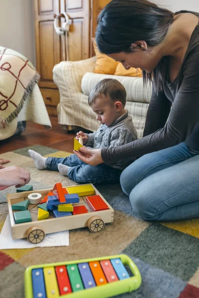 Mutter spielt mit Kleinkind ein Holzspielhaus — Stockfoto