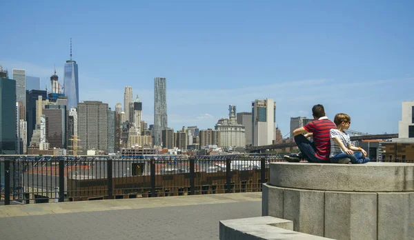 Hombre y niño sentados frente al horizonte de Manhattan, en la ciudad de Nueva York — Foto de Stock