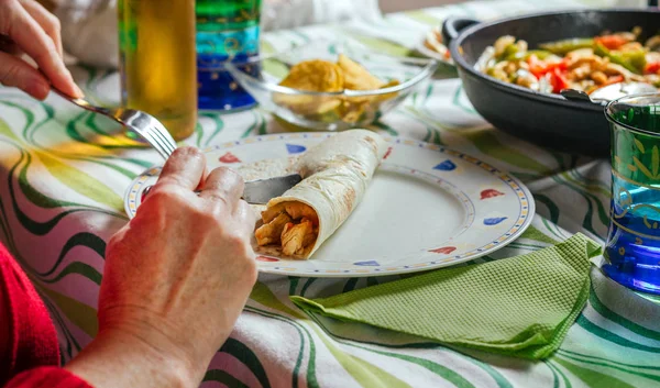 Woman rolling mexican fajita on the plate — Stock Photo, Image