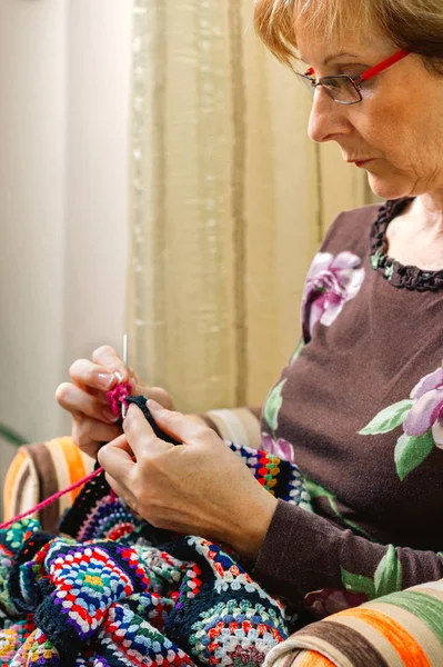 Portrait of woman knitting a vintage wool quilt — Stock Photo, Image