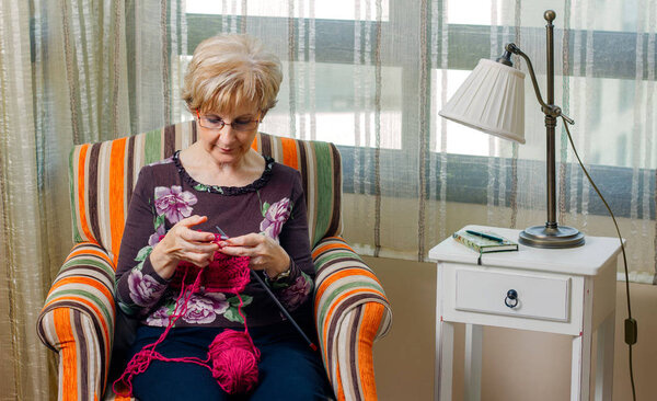 Portrait of woman knitting a wool sweater