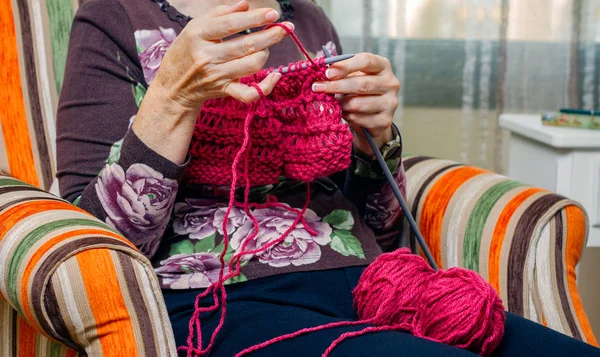 Руки женщины, вязавшей шерстяной свитер — стоковое фото