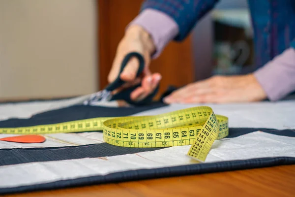Measuring tape with dressmaker cutting in background — Stock Photo, Image