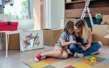 Halı üzerinde oturan üzgün oğlu rahatlatıcı anne