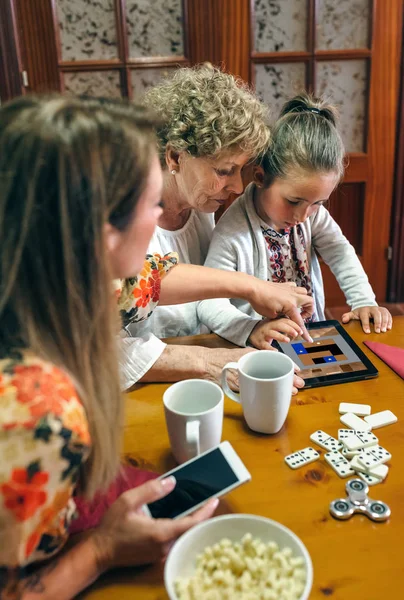 Бабушка и внучка играют в игру на планшете — стоковое фото