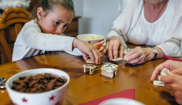 Liten jente som leker domino med mor og bestemor – stockfoto