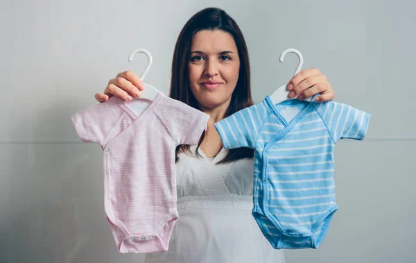 Embarazada mostrando baby bodysuits — Foto de Stock