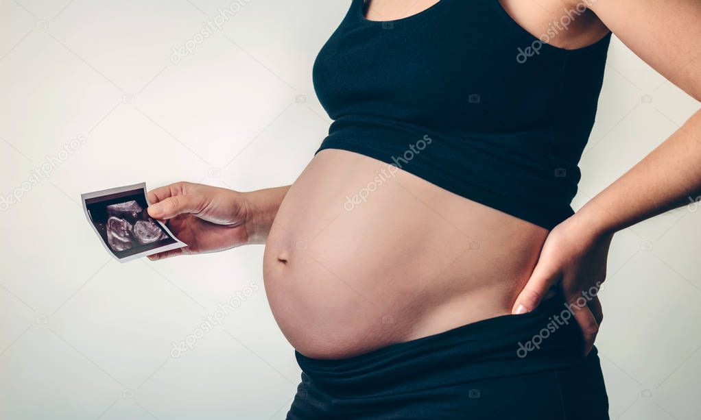 Pregnant woman holding an ultrasound