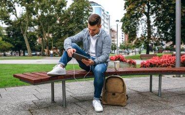 genç adam açık havada tablet kullanma