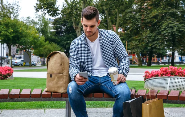 Man looking mobile sitting on a bench — Stock Photo, Image