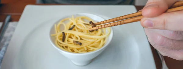 Mannen äter spagetti och syrsor — Stockfoto