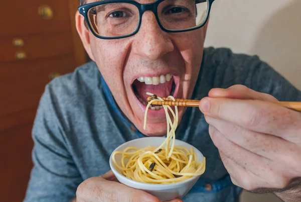 Mężczyzna jedzenie spaghetti i świerszczy — Zdjęcie stockowe