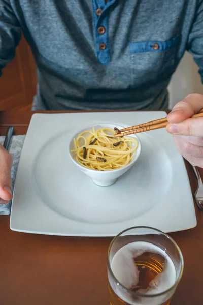 Hombre Irreconocible Comiendo Espaguetis Grillos Con Palillos —  Fotos de Stock