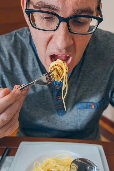 Человек ест спагетти с червями — стоковое фото