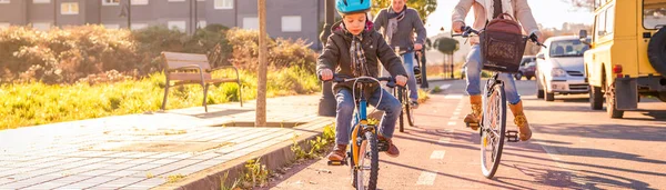 市内で自転車に乗る子供と家族 — ストック写真