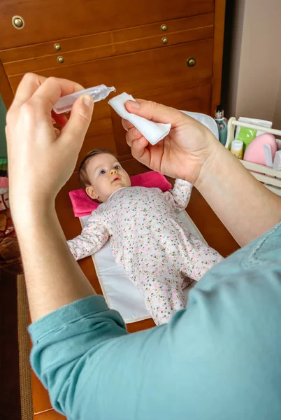 Anne bebek gözleri temizlemek için bir boşaltma serum eller — Stok fotoğraf