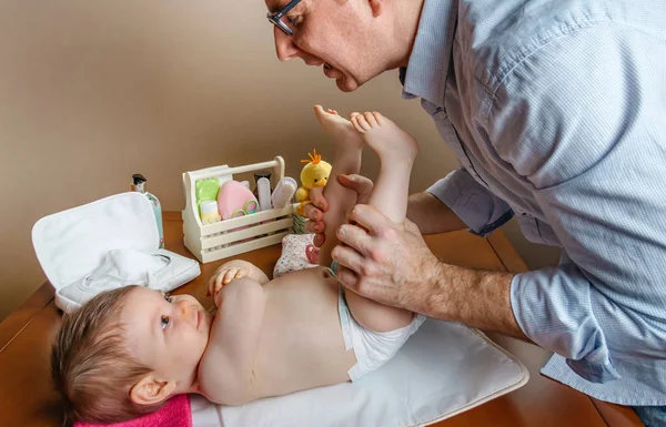 Bebek kızıyla birlikte değişen masada oynama baba — Stok fotoğraf