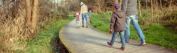 Family walking together holding hands in the forest — Stock Photo, Image