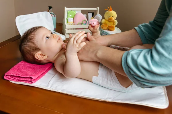 Mãe massageando corpo de seu bebê deitado — Fotografia de Stock
