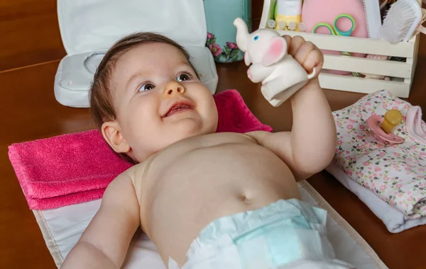 Bebé acostado jugando con un juguete de goma — Foto de Stock