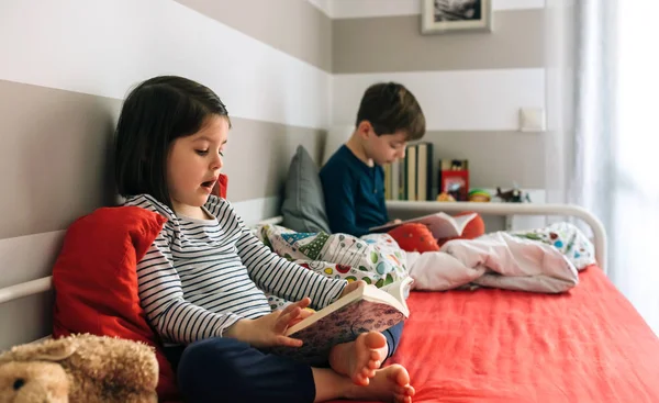 Flicka och pojke läser en bok — Stockfoto