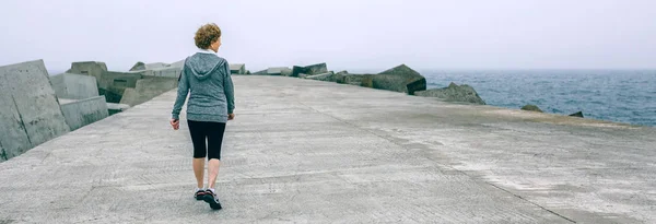 Zadní pohled na ženy, chůze u moře molo — Stock fotografie