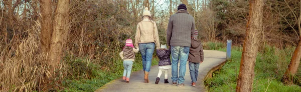 Family walking together holding hands in the forest — Stock Photo, Image