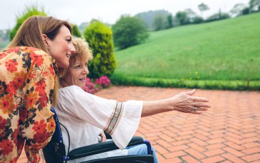 Kızıyla birlikte tekerlekli sandalyedeki kadın kıdemli