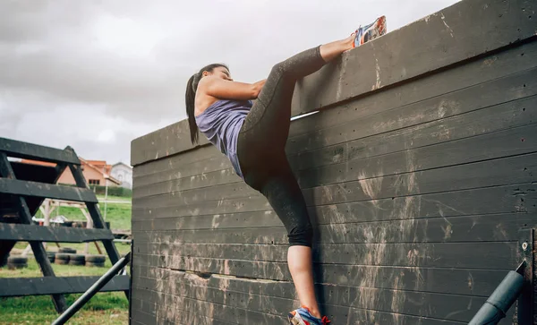 Participant in obstacle course climbing wall — Stock Photo, Image