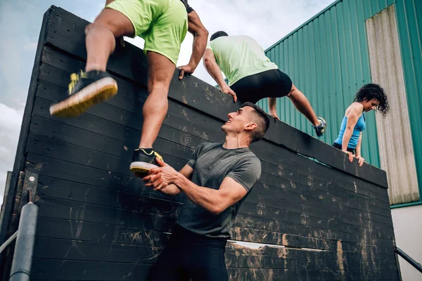 Participants in obstacle course climbing wall — Stock Photo, Image
