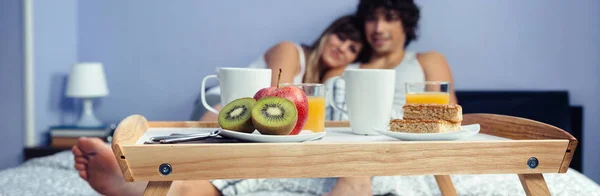 Terveellinen aamiainen tarjottimella ja pari makaa taustalla — kuvapankkivalokuva
